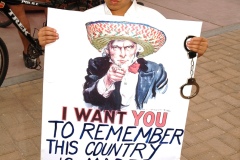Issac Pompalo holds a sign and handcuffs during the Immigration Rally held in El Paso, TX on April 10.